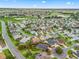 Beautiful aerial view of a single-Gathering home in a quiet neighborhood with lush landscaping and a nearby golf course at 654 Poinsett Ct, The Villages, FL 32162