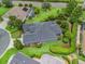 Aerial view of a meticulously landscaped backyard featuring hedges, lawns, and beautiful gray home at 654 Poinsett Ct, The Villages, FL 32162