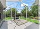 Back lanai features hot tub with surrounding lawn and landscaping at 654 Poinsett Ct, The Villages, FL 32162