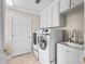 Well-lit laundry room featuring modern appliances, sink, and ample cabinet storage at 654 Poinsett Ct, The Villages, FL 32162