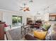 Spacious living room featuring a ceiling fan, leather furniture, and sliding doors to the patio at 654 Poinsett Ct, The Villages, FL 32162