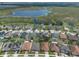 Aerial view of a residential community and neighborhood with homes and a lake at 686 Black Eagle Dr, Groveland, FL 34736