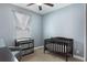 Neutral Bedroom showcasing modern baby furniture, soft carpet, and light blue walls at 686 Black Eagle Dr, Groveland, FL 34736