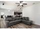 Open living space with wood floors, a large sectional couch, ceiling fan and an open view into the kitchen at 686 Black Eagle Dr, Groveland, FL 34736