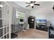Bright home office features a computer desk, large window, ceiling fan, and light carpet at 686 Black Eagle Dr, Groveland, FL 34736
