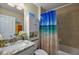 Bathroom with white vanity, shower/tub, and attractive blue-themed shower curtain at 7162 Se 124Th St, Belleview, FL 34420
