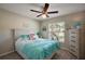 Inviting bedroom featuring a ceiling fan, comfortable bed and lots of natural light at 7162 Se 124Th St, Belleview, FL 34420