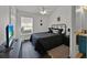 Cozy bedroom with dark wood floors, ceiling fan, and a large window offering natural light at 802 Balmoral Dr, Davenport, FL 33896