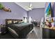 This bedroom is painted purple and has a bed, ceiling fan, and black accents at 802 Balmoral Dr, Davenport, FL 33896