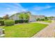 Well-maintained single-story home with green lawn, mature landscaping and a brick-paved driveway at 802 Balmoral Dr, Davenport, FL 33896
