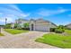 Beautiful single-story home featuring a brick-paved driveway and lush green landscaping at 802 Balmoral Dr, Davenport, FL 33896