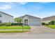 Charming single-story home with a well-manicured lawn, mature palm trees, and a brick-paved driveway at 802 Balmoral Dr, Davenport, FL 33896