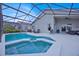 Relaxing screened-in pool and spa area with loungers and an umbrella-covered table at 802 Balmoral Dr, Davenport, FL 33896