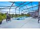 Screened-in pool and spa with poolside seating offering serene views of the backyard at 802 Balmoral Dr, Davenport, FL 33896