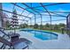 Inviting screened-in pool and spa surrounded by lounge chairs and lush greenery at 802 Balmoral Dr, Davenport, FL 33896