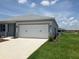 Spacious two-car garage with a concrete driveway, attached to a well-maintained single-story home at 8855 Sw 72Nd Loop, Ocala, FL 34481