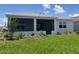 Back exterior view with a screened lanai and well-maintained landscaping, perfect for outdoor living at 8855 Sw 72Nd Loop, Ocala, FL 34481