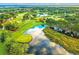 Stunning aerial view of a golf course with ponds, lush greenery, and clear blue skies at 9220 San Jose Blvd, Howey In The Hills, FL 34737