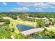 Stunning aerial view of a golf course community with a bridge, pond, and lush green fairways in a serene setting at 9220 San Jose Blvd, Howey In The Hills, FL 34737