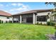 The expansive backyard showcases lush green grass and a screened patio for outdoor enjoyment at 9220 San Jose Blvd, Howey In The Hills, FL 34737