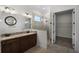 Bathroom featuring double sinks, granite countertops, a glass shower, and a walk-in closet at 9220 San Jose Blvd, Howey In The Hills, FL 34737