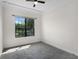 An empty carpeted bedroom is brightly lit by a window, with modern ceiling fan at 9220 San Jose Blvd, Howey In The Hills, FL 34737