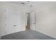 An empty carpeted bedroom includes a large closet and an open doorway to another room at 9220 San Jose Blvd, Howey In The Hills, FL 34737