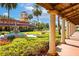 Beautifully landscaped exterior with fountains, gardens, tower, and covered walkway adorned with stately pillars at 9220 San Jose Blvd, Howey In The Hills, FL 34737