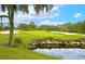 Picturesque golf course with sand traps, green grass, and a tranquil pond surrounded by lush greenery at 9220 San Jose Blvd, Howey In The Hills, FL 34737