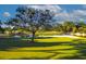 Picturesque golf course featuring green fairways, a serene pond, and mature trees under a partly cloudy sky at 9220 San Jose Blvd, Howey In The Hills, FL 34737