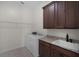 Bright laundry room features modern washer and dryer, granite countertops, and rich wood cabinetry at 9220 San Jose Blvd, Howey In The Hills, FL 34737