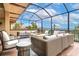 A luxurious screened patio features comfortable seating and a cozy fire pit, perfect for outdoor relaxation and entertainment at 9220 San Jose Blvd, Howey In The Hills, FL 34737