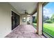 A screened patio with brick flooring offers peaceful outdoor living and views of manicured greenery at 9220 San Jose Blvd, Howey In The Hills, FL 34737