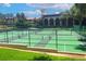 Well-maintained tennis courts surrounded by lush landscaping and a view of the main building at 9220 San Jose Blvd, Howey In The Hills, FL 34737