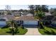 Well-maintained single-story home with three-car garage, lush landscaping, and mature palm trees at 9430 Se 176Th Saffold St, The Villages, FL 32162