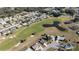 Scenic aerial view of homes bordering a golf course and pond enhancing community aesthetics at 9430 Se 176Th Saffold St, The Villages, FL 32162