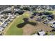 Picturesque aerial perspective showcasing homes near a golf course, pond, and green spaces at 9430 Se 176Th Saffold St, The Villages, FL 32162