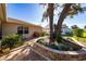 Landscaped backyard featuring a brick patio, lush greenery, and mature trees at 9430 Se 176Th Saffold St, The Villages, FL 32162