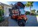 Bright orange golf cart parked on the driveway of a home at 9430 Se 176Th Saffold St, The Villages, FL 32162