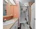 Bathroom featuring a single vanity, decorative mirror, a tile shower and plank flooring at 9483 Cr 747, Webster, FL 33597
