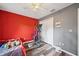 Bedroom features wood-look floors, neutral gray paint, and bright red accent wall at 9483 Cr 747, Webster, FL 33597
