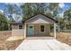 Charming single-story home features a stylish exterior with a blue front door and a well-lit porch area at Lot 21 Indian Estates Cr 423, Lake Panasoffkee, FL 33538