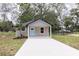 Charming single-story home with a welcoming light blue front door and a concrete driveway at Lot 21 Indian Estates Cr 423, Lake Panasoffkee, FL 33538