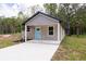 Charming single-story home with a welcoming light blue front door and a concrete driveway at Lot 21 Indian Estates Cr 423, Lake Panasoffkee, FL 33538