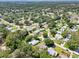 Beautiful aerial view of a neighborhood with lush landscaping and a tranquil lake in the distance at 1011 Dundee Cir, Leesburg, FL 34788