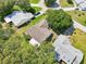 Aerial view highlighting a home with a well-maintained lawn, surrounded by lush green trees at 1011 Dundee Cir, Leesburg, FL 34788