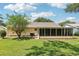 Backyard view showing sunroom and landscaping at 1011 Dundee Cir, Leesburg, FL 34788
