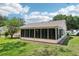 Backyard view showing sunroom and landscaping at 1011 Dundee Cir, Leesburg, FL 34788