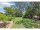 Expansive backyard featuring lush lawn and mature trees offering shade and privacy at 1011 Dundee Cir, Leesburg, FL 34788