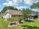 Landscaped backyard featuring a combination of lawn, trees, and a screened-in patio at 1011 Dundee Cir, Leesburg, FL 34788